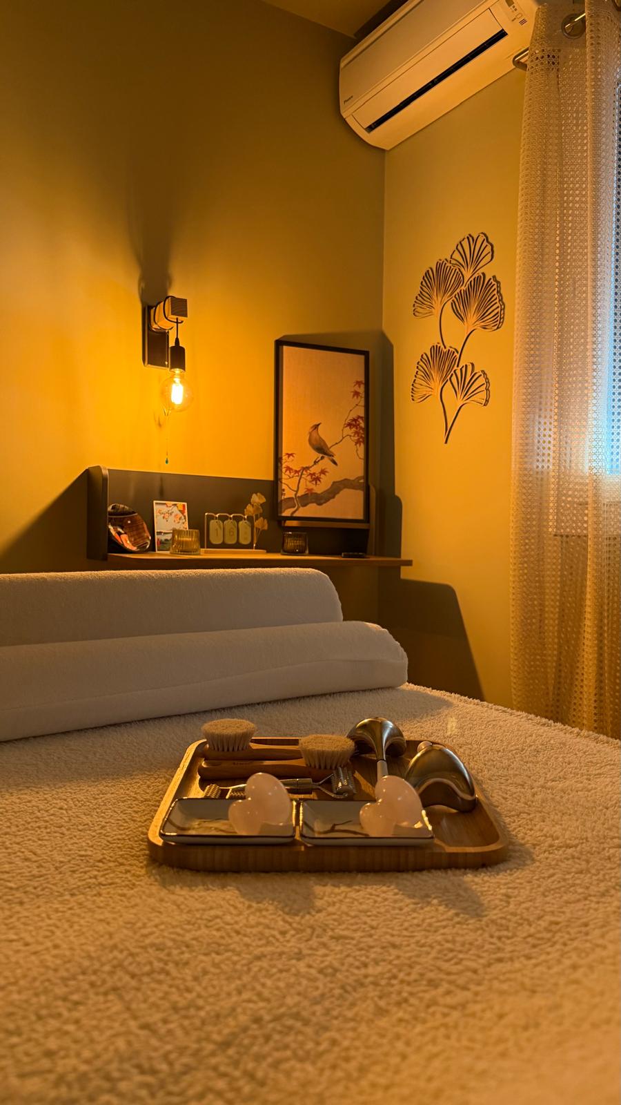 La table de massage et son plateau, dans la lumière chaude de la cabine.